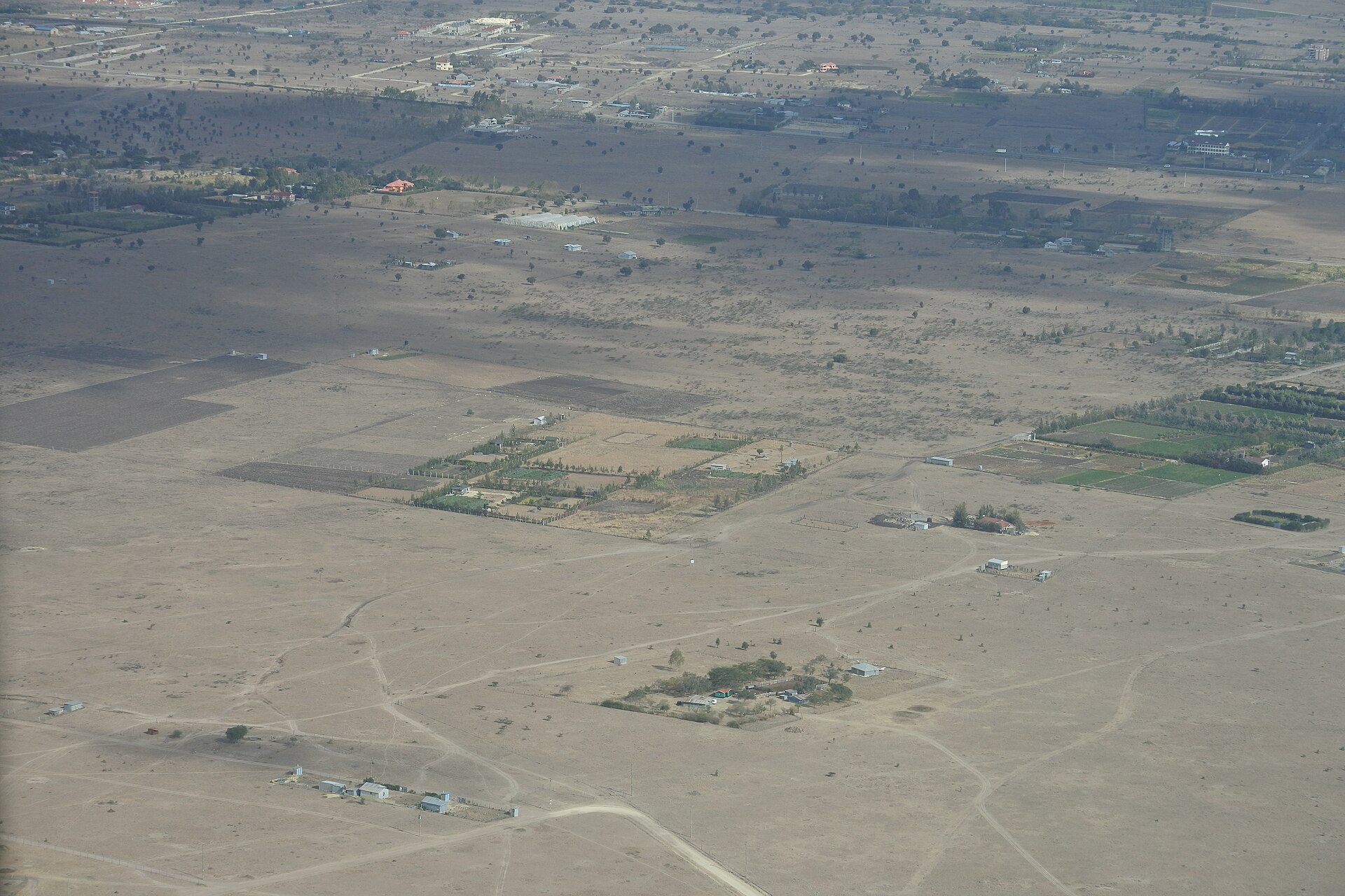 Aerial view of demarcated Kenyan land parcels with plots, tracks, and homesteads — the land an ArdhiScore is built to verify